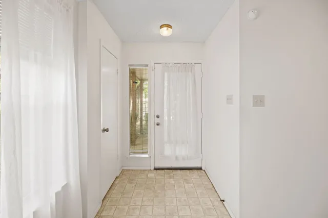 a view of an empty room with a fireplace and a window