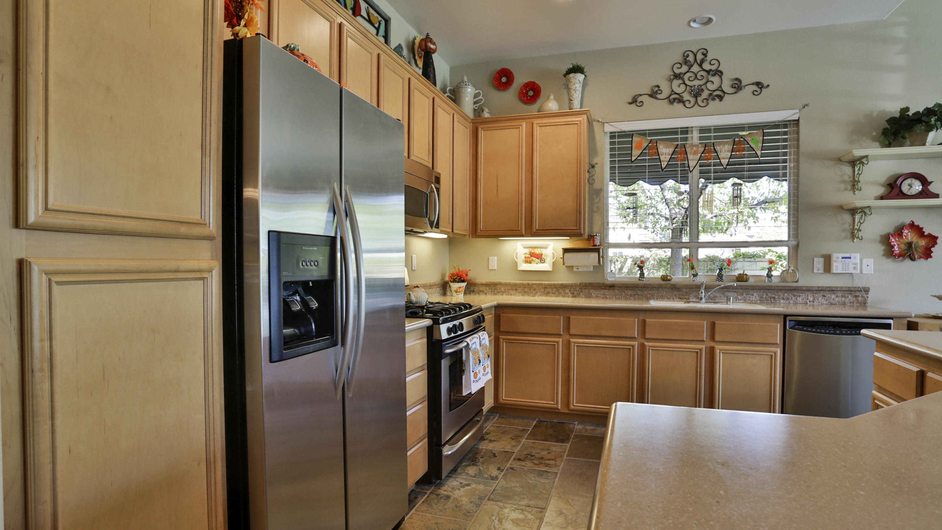 1598 Thunderbird Road Beaumont, CA 92223 - Photo 7 of 52 a kitchen with stainless steel appliances granite countertop a refrigerator a sink dishwasher a stove and a dining table with wooden floor