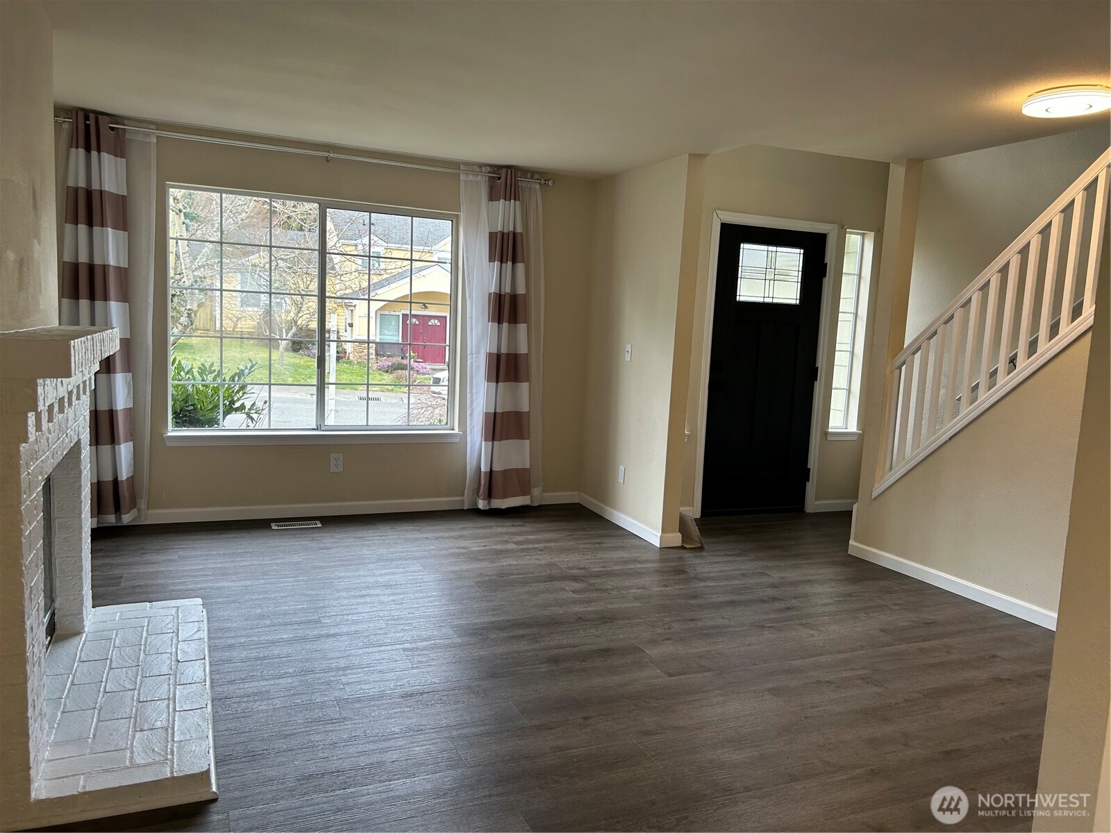 17832 114th Place Southeast Renton, WA 98055 - Photo 7 of 20 a view of an empty room with wooden floor and a window