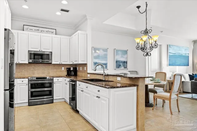 a kitchen with kitchen island granite countertop white cabinets and stainless steel appliances