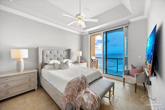 a bedroom with a bed a couch and a flat tv screen on dresser