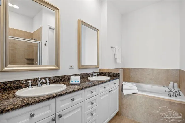 a bathroom with double vanity sinks double vanity tub and a mirror