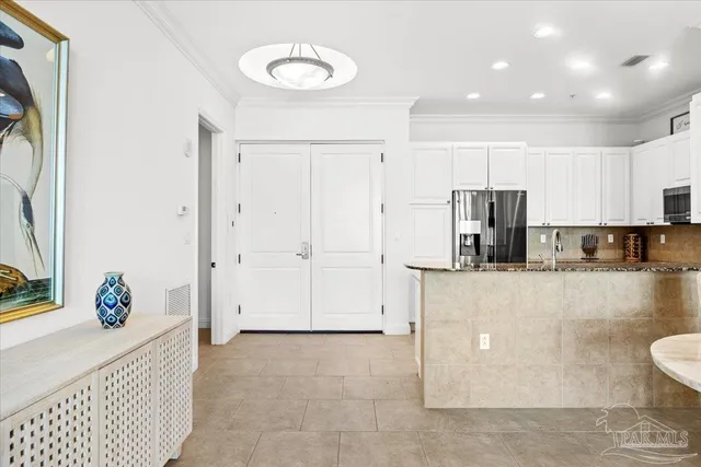 a view of kitchen with stainless steel appliances wooden floor and chair