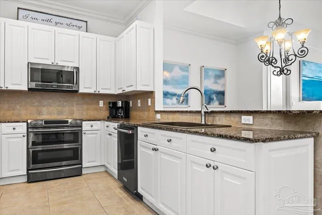 a kitchen with granite countertop a sink stainless steel appliances and white cabinets