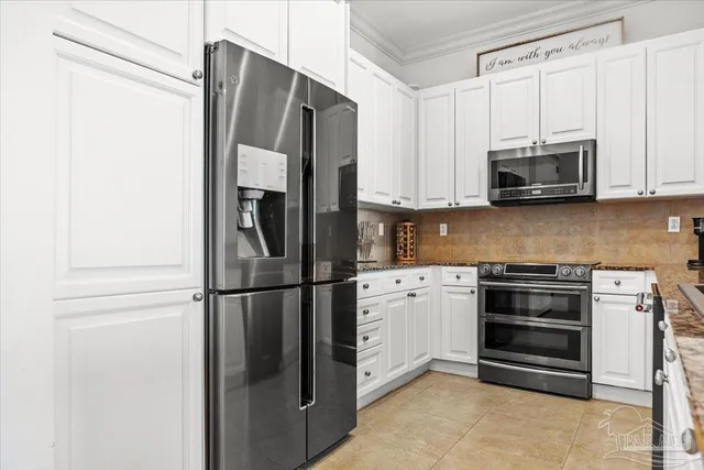 a kitchen with stainless steel appliances granite countertop a refrigerator and a stove top oven