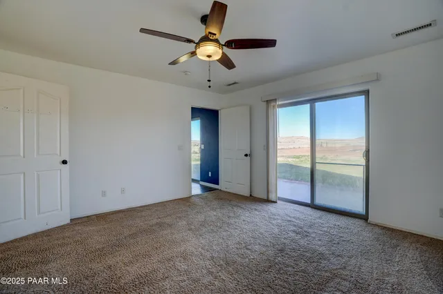 a view of an empty room and a ceiling fan