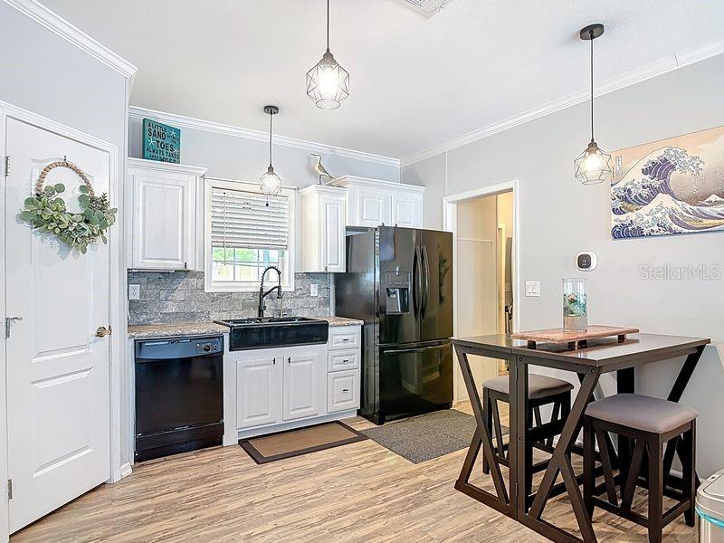 102 Ash Street Edgewater, FL 32141 - Photo 10 of 36 a kitchen with stainless steel appliances kitchen island granite countertop a dining table chairs and white cabinets