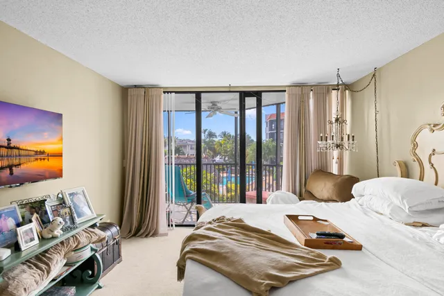 a bedroom with a bed and large windows