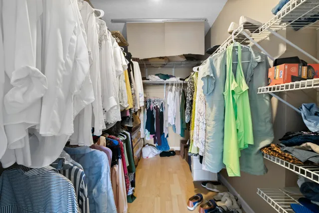 a view of walk in closet with clothes and shoes