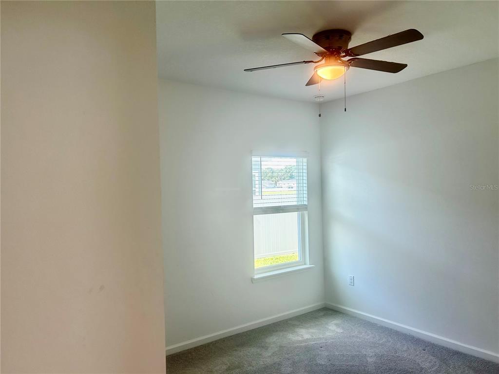 4530 Northwest 14th Loop Ocala, FL 34482 - Photo 31 of 40 an empty room with window and ceiling fan