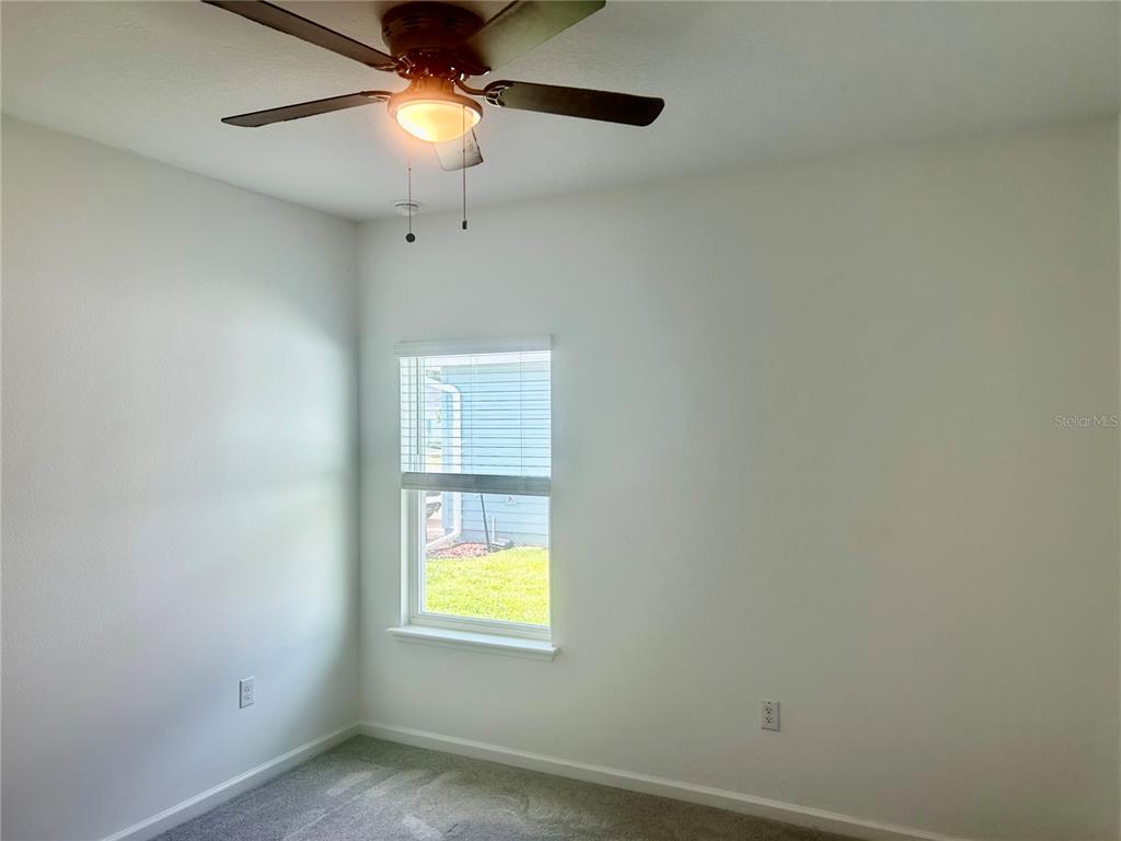 4530 Northwest 14th Loop Ocala, FL 34482 - Photo 36 of 40 an empty room with a window and chandelier fan