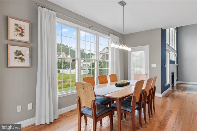 a dining room with furniture window and wooden floor