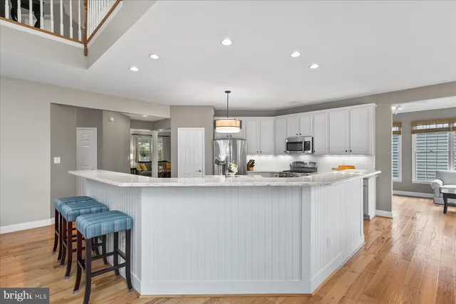 a kitchen with kitchen island granite countertop a sink stainless steel appliances and cabinets