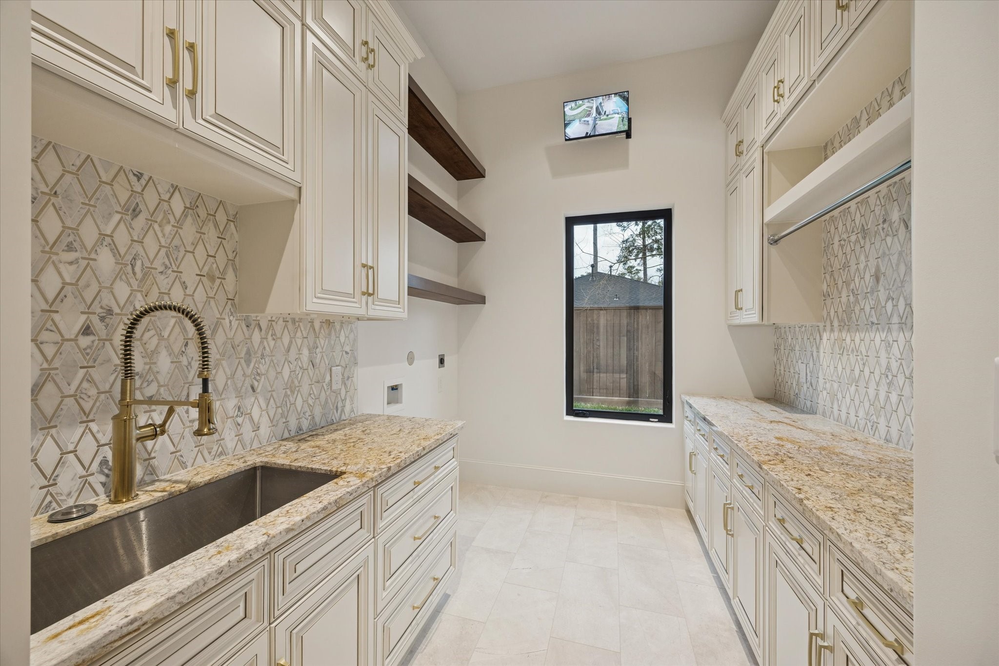 318 Knipp Road Houston, TX 77024 - Photo 24 of 32 Will-appointed first-floor utility room features custom cabinetry, extenstive storage, a secondary refrigerator, and abundant workspace designed for everyday convenience.