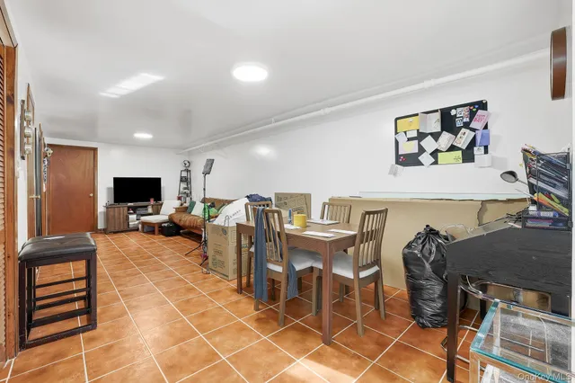 a living room with furniture a flat screen tv and kitchen view