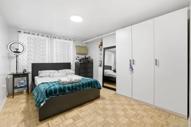 a large bedroom with a bed and a refrigerator