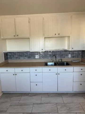 a kitchen with white cabinets and white appliances