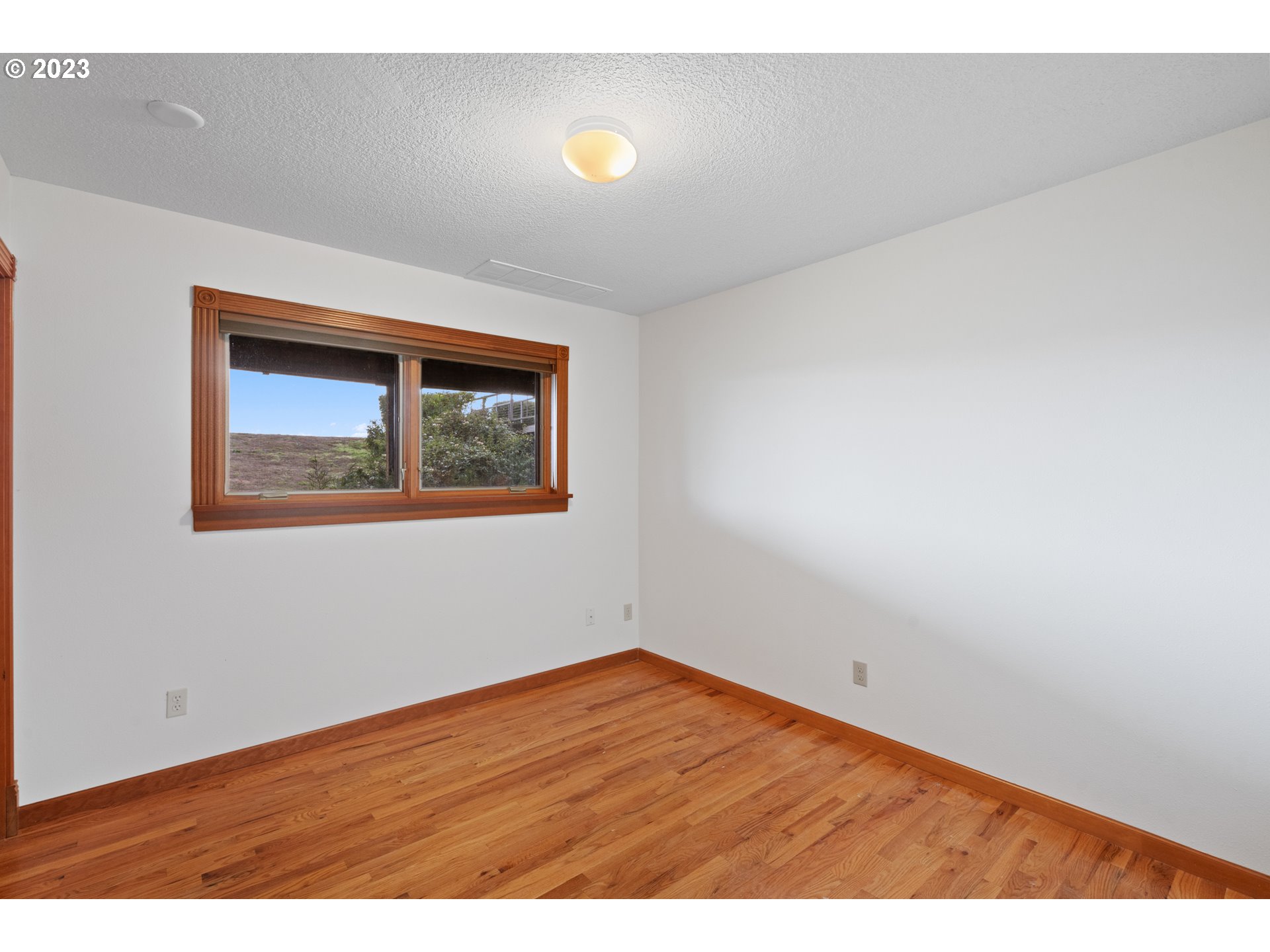 15140 Northwest Gillihan Road Portland, OR 97231 - Photo 24 of 34 a view of an empty room with wooden floor and a window