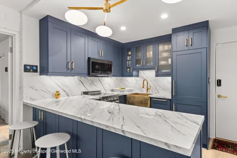 a kitchen with kitchen island a stove a sink and a refrigerator with wooden floor