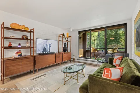 a living room with furniture and a floor to ceiling window