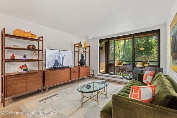 a living room with furniture and a floor to ceiling window