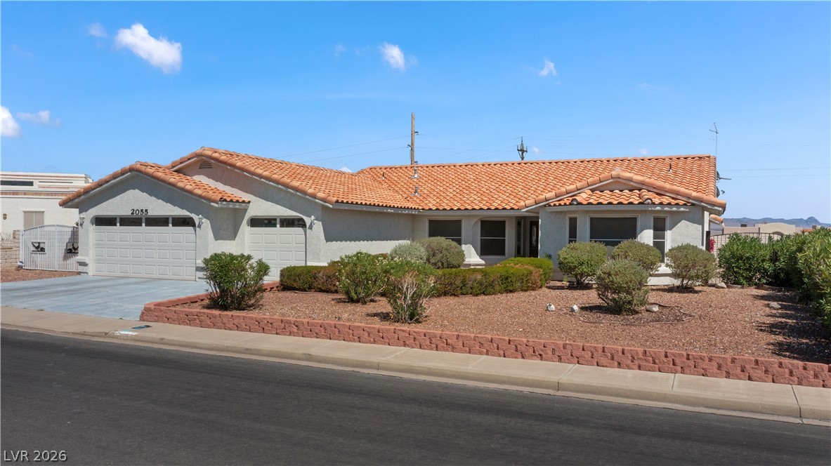 2055 Cholla Way Laughlin, NV 89029 - Photo 63 of 87 A terracotta-tiled roof crowns this residence, featuring a two-car garage and xeriscaped front yard.