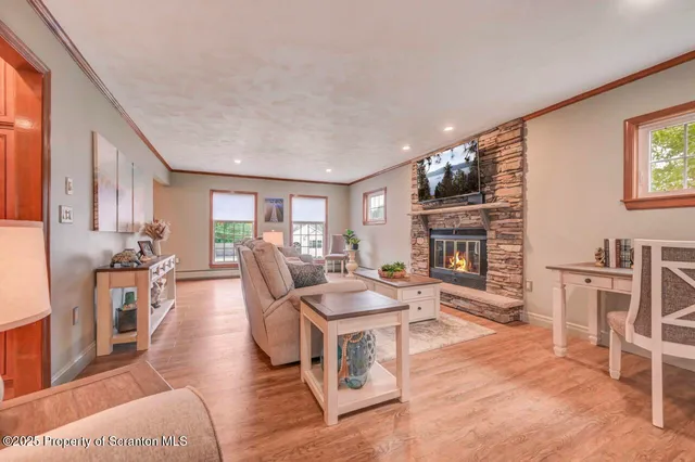 a living room with stainless steel appliances furniture a rug and a view of kitchen