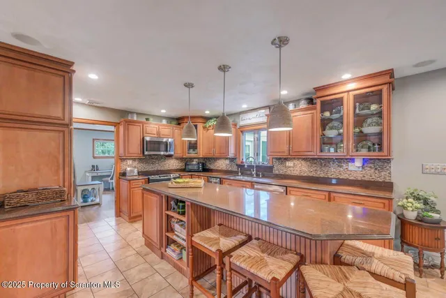 a kitchen with stainless steel appliances granite countertop a sink and a refrigerator