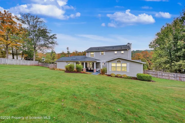 a view of a house with a big yard and large trees