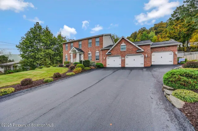 a view of a big house with a big yard and large trees