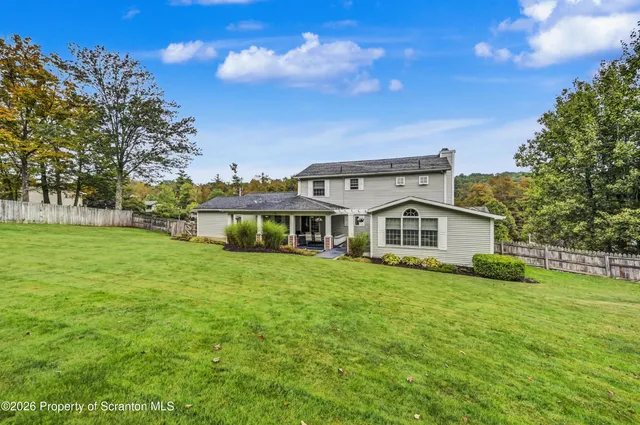 a living room with patio furniture and a garden