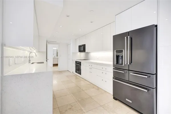 a kitchen with granite countertop a stove and white cabinets