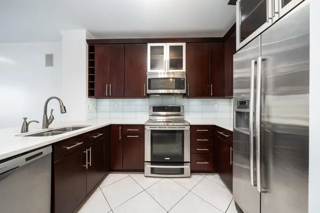 a kitchen with stainless steel appliances granite countertop a refrigerator and a sink