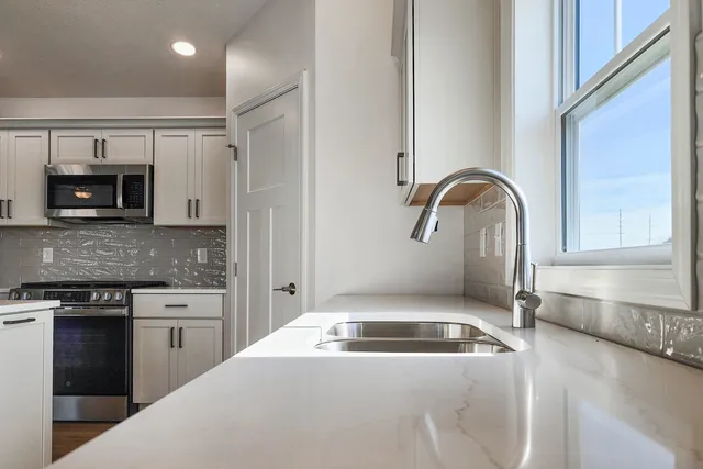 a kitchen with a stove and white cabinets