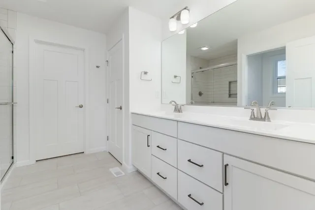 a bathroom with double sink and a mirror
