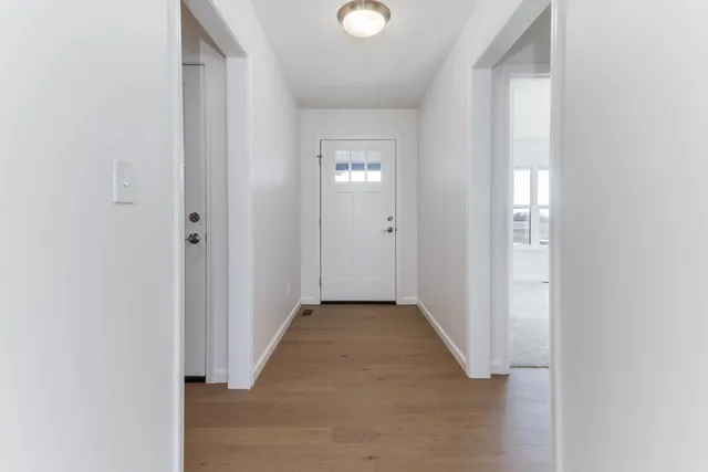 a view of a hallway with wooden floor