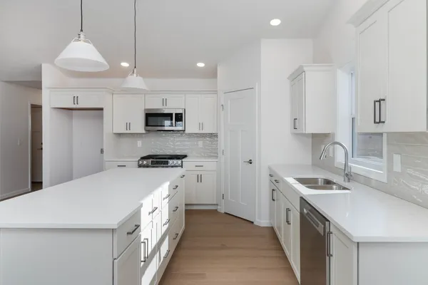 a kitchen with stainless steel appliances granite countertop a sink stove and refrigerator