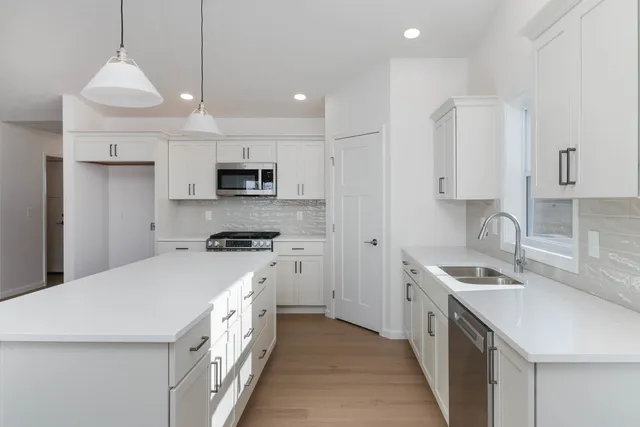 a kitchen with stainless steel appliances granite countertop a sink stove and refrigerator