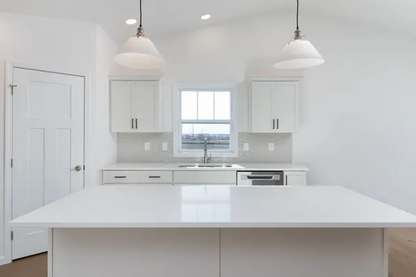 a kitchen with stainless steel appliances a sink a stove a refrigerator and cabinets