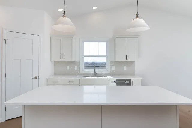 a kitchen with stainless steel appliances a sink a stove a refrigerator and cabinets