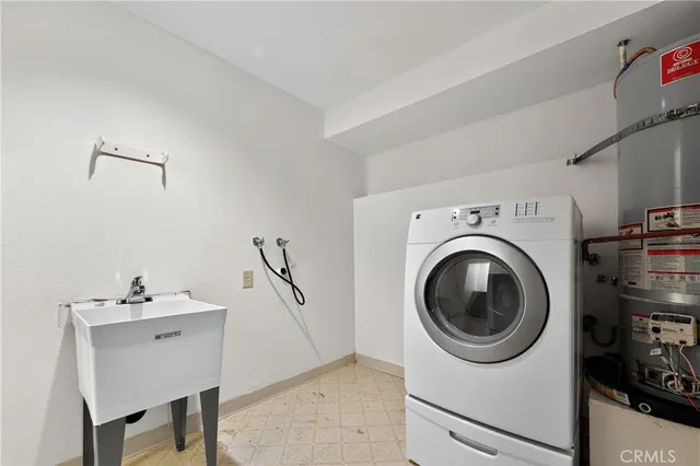 a utility room with sink dryer and washer