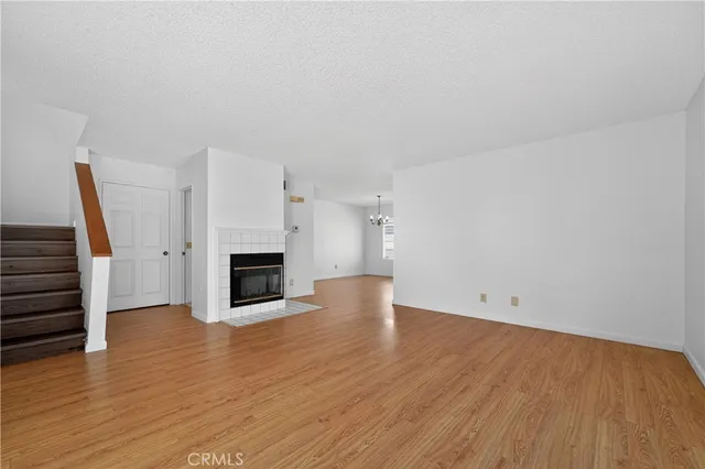 an empty room with wooden floor and fireplace