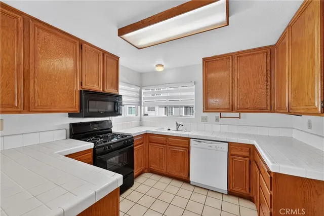 a kitchen with stainless steel appliances granite countertop a sink stove refrigerator and cabinets