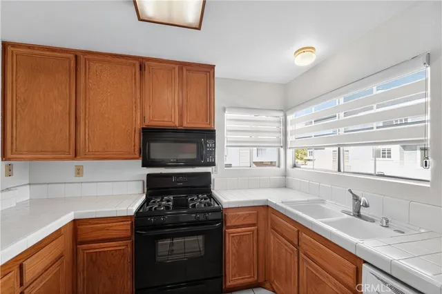 a kitchen with a sink stove top oven and cabinets