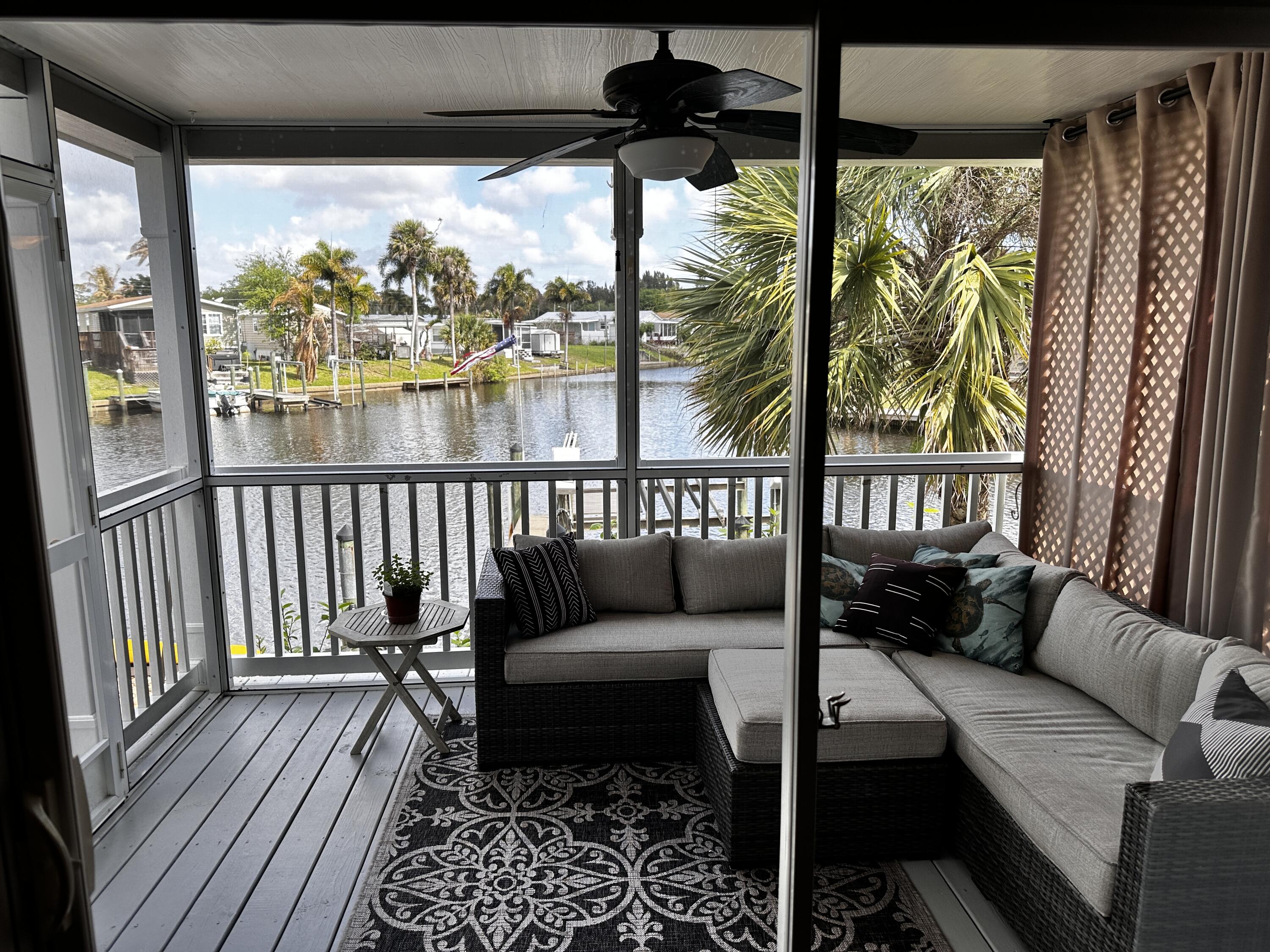 121 Southeast Paradise Place Stuart, FL 34997 - Photo 12 of 33 a living room with furniture and a floor to ceiling window