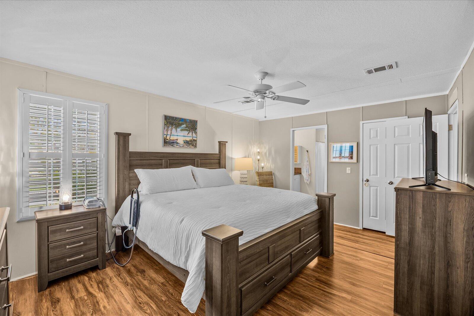 121 Southeast Paradise Place Stuart, FL 34997 - Photo 13 of 33 a bedroom with a bed and a chandelier