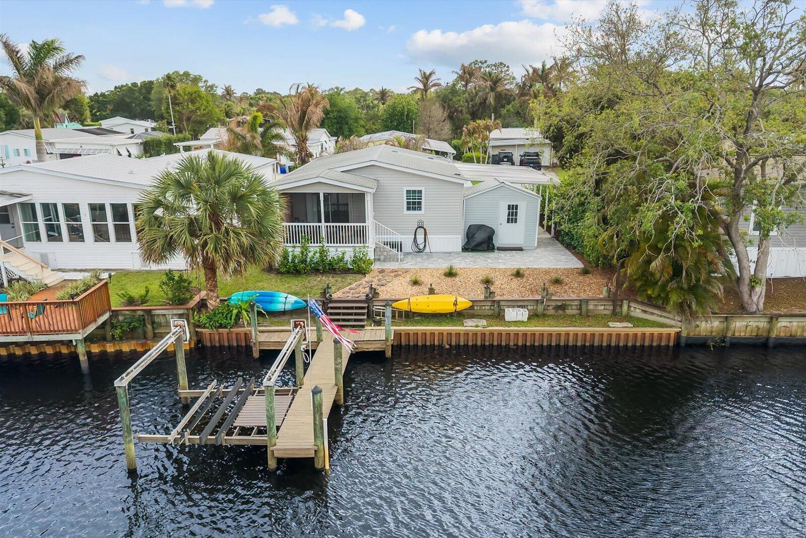 121 Southeast Paradise Place Stuart, FL 34997 - Photo 2 of 33 a view of a white house with a chairs in a patio