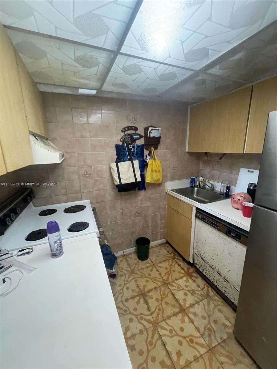 777 Southwest 9th Avenue, Unit 314 Miami, FL 33130 - Photo 4 of 8 a kitchen with a sink a stove and cabinets