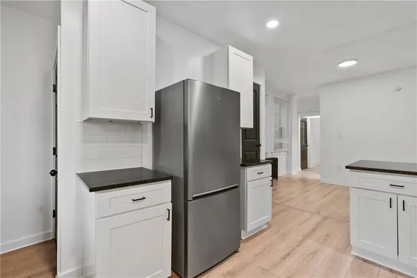 a kitchen with a refrigerator and a stove top oven