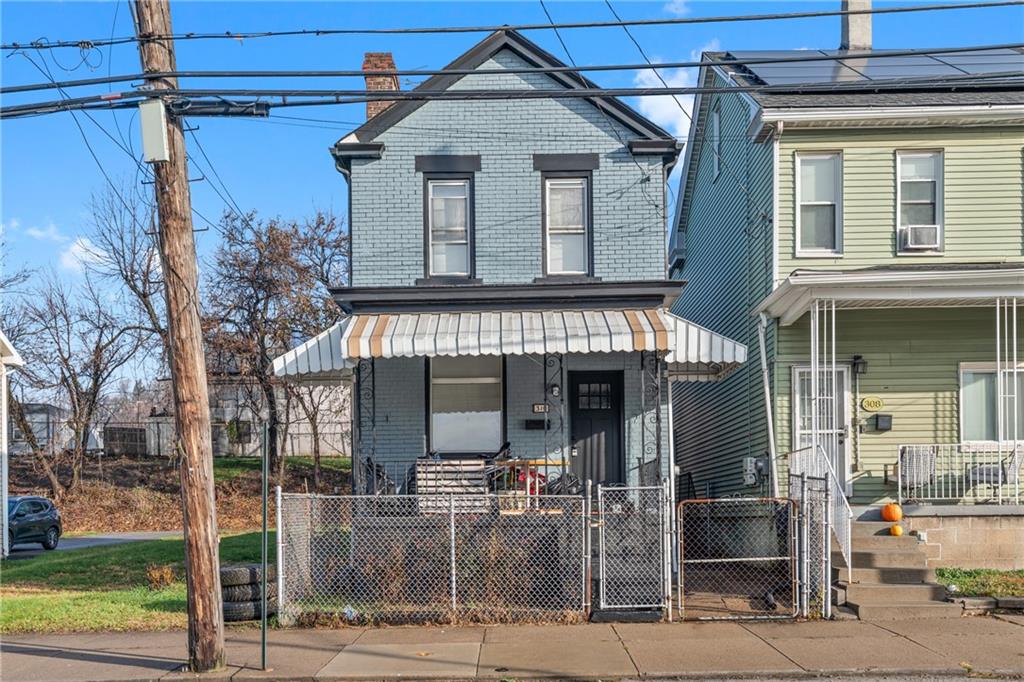 310 5th Avenue Braddock, PA 15104 - Photo 2 of 26 a view of a brick house with large windows and a table and chairs